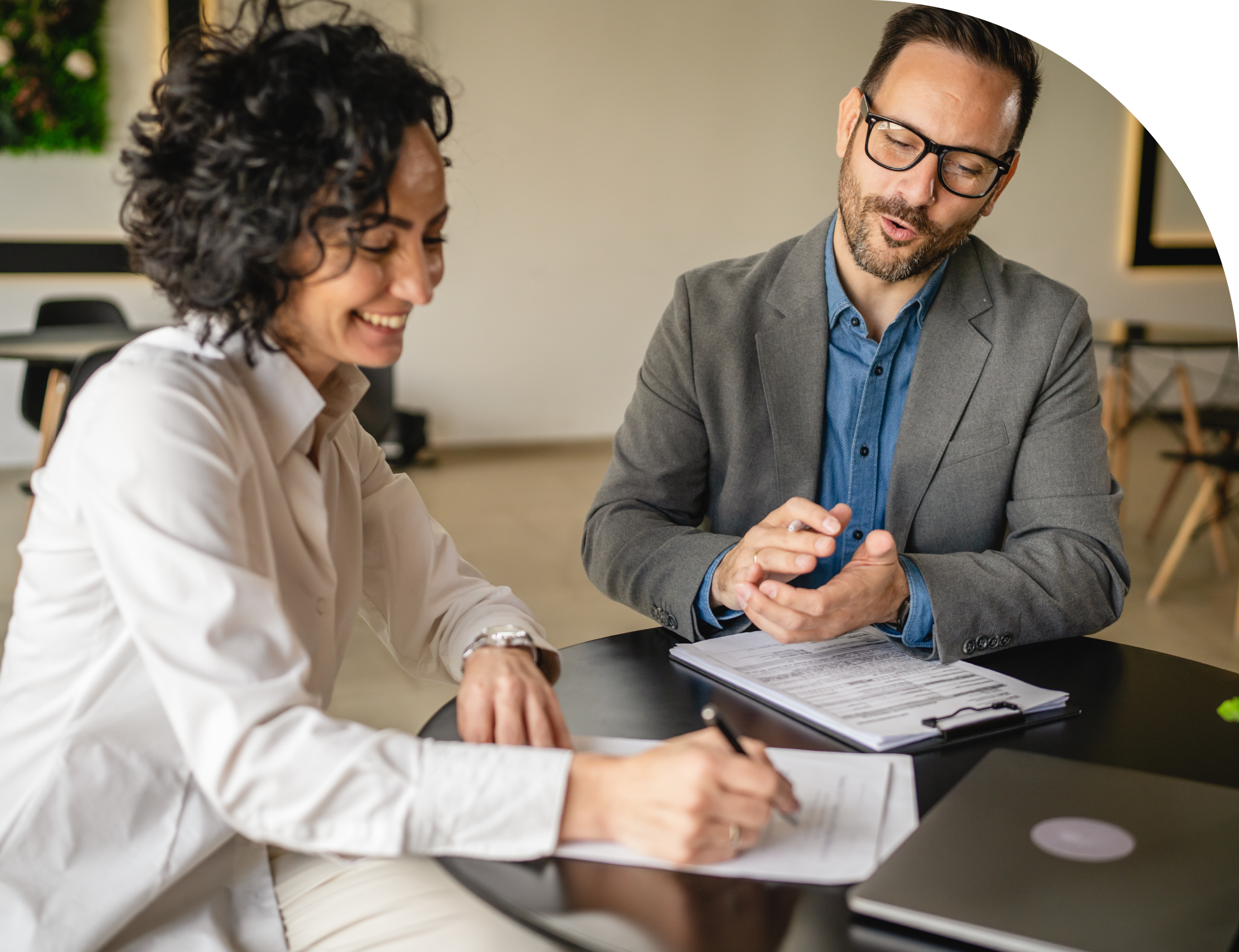 femme-souriante-signant-contrat-et-homme-qui-felicite